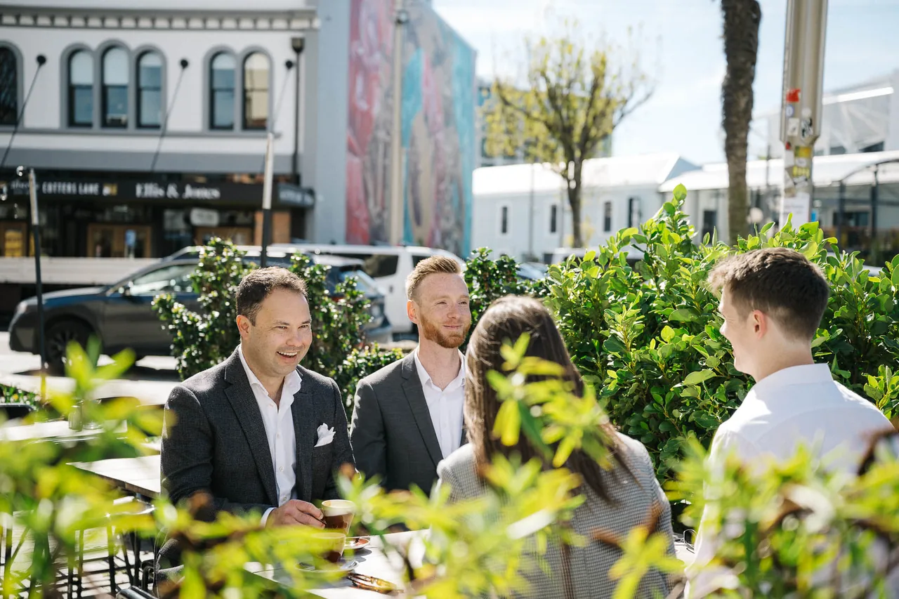 The 9 Yards team at an outdoor cafe table in Christchurch